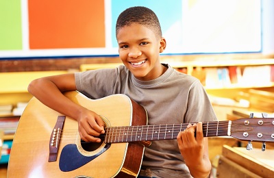 Adult holding a guitar with a child