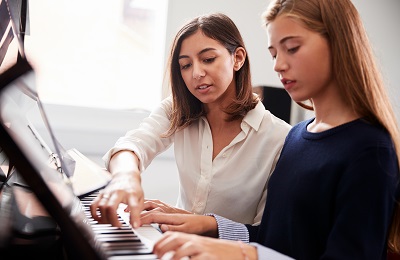 Adult and children sitting at a piano